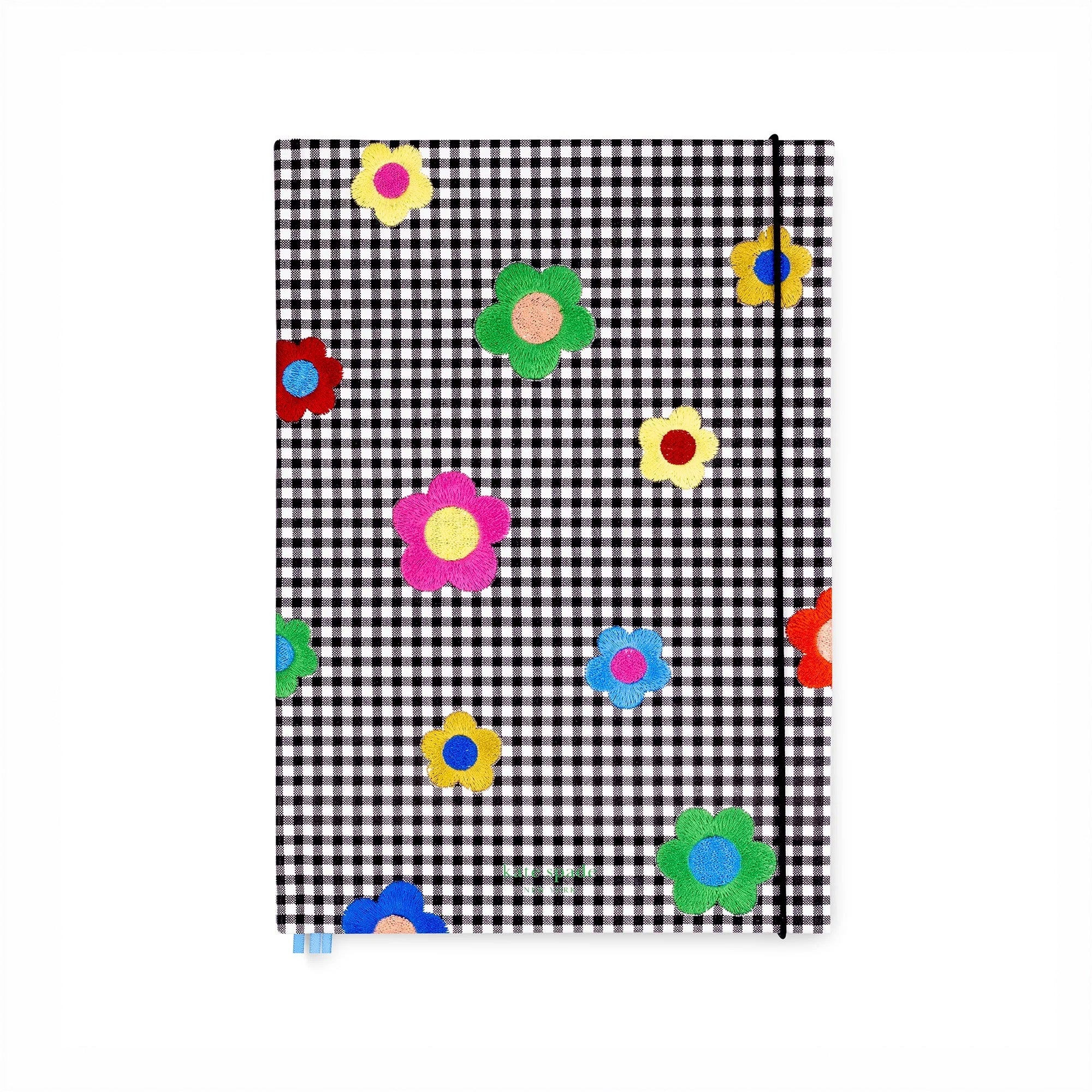 Notebook with black and white checkered pattern and colorful flowers on a white background