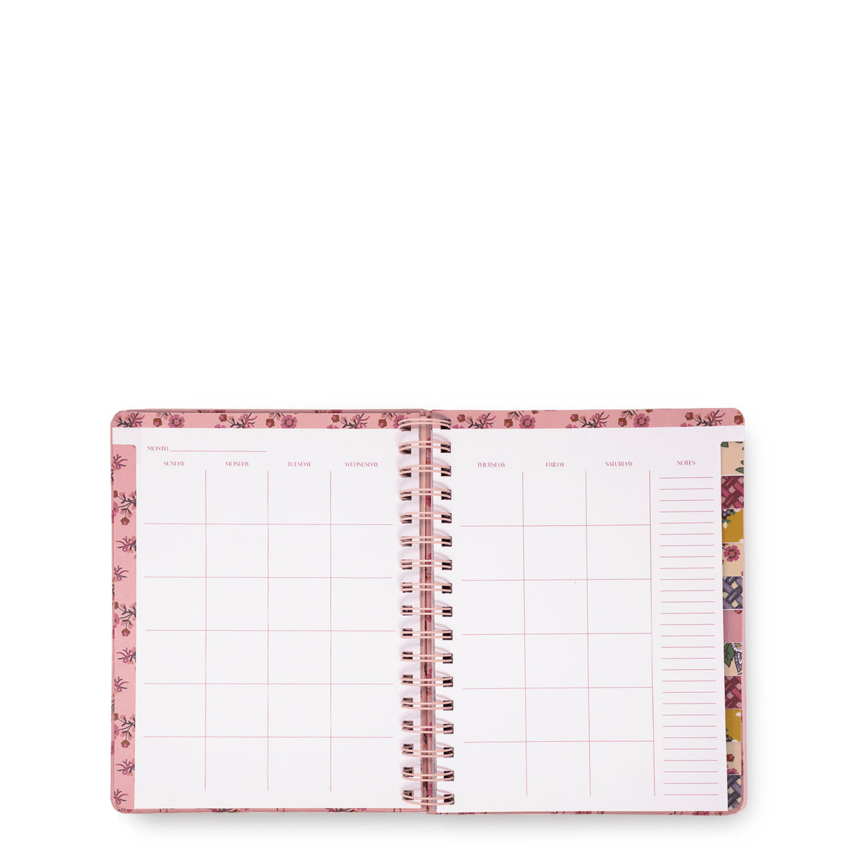 An open spiral-bound planner or agenda with pink floral-patterned covers and white interior pages featuring grid and lined sections, photographed on a plain white background.