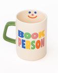 Mug with a smiley face and colorful text on a white background