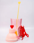 Bar set with pink shaker, red strainer and yellow heart stir spoon