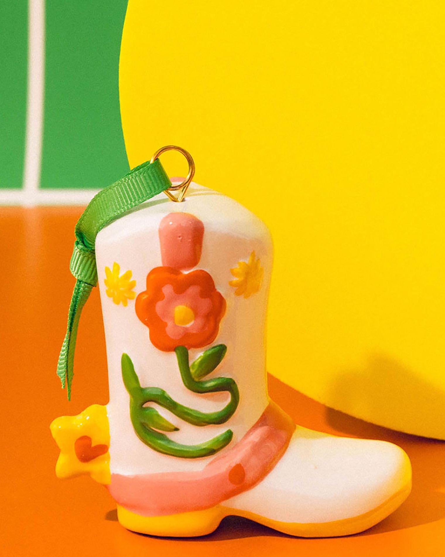 Colorful boot-shaped keychain with floral design on a multicolored background
