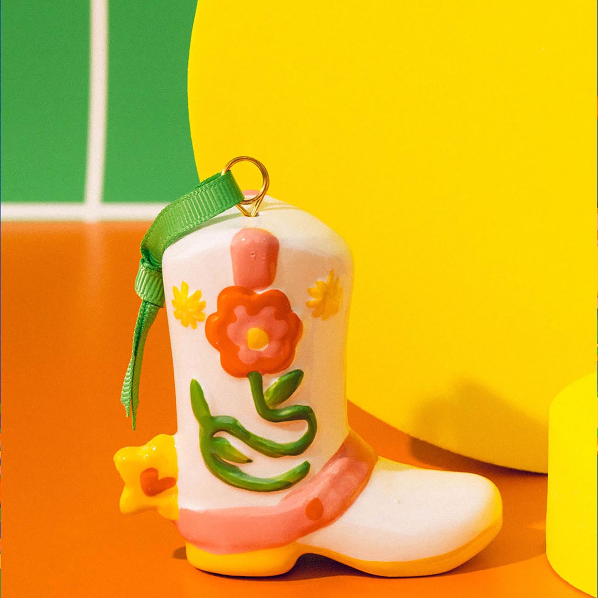 Colorful boot-shaped keychain with floral design on a multicolored background