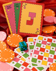 Colorful playing cards and poker chips on a red fabric background