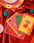 Colorful playing cards and poker chips on a red fabric background