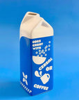 Blue and white milk carton-shaped vase on a blue background