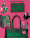 Collection of green and pink stationery items on a pink background