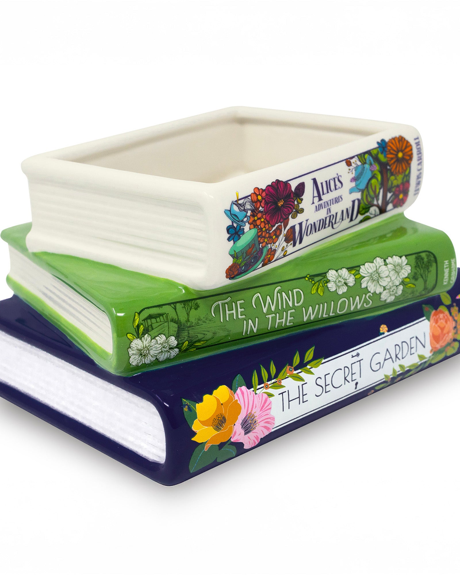 Stack of ceramic book-shaped planters with book title designs on a white background