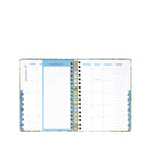 An open spiral-bound planner showing a monthly calendar layout with lined 'things to do' sections, photographed on a plain white background.