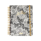 A spiral-bound planner featuring a black and white zebra print cover with gold foil accents, including a scalloped gold border and gold lettering.