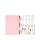 An open spiral-bound planner or agenda showing a light pink page on the left and a sticker sheet on the right with small icons and words such as 'party', 'work', 'to do', and 'don't forget'.