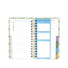 An open spiral-bound planner showing a January 2027 calendar page, a blue monthly manifestations section, and colorful tabs on the right, photographed on a white background.