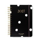 Kate Spade 2027 spiral-bound planner in black with white polka dots, gold lettering, and a pink elastic closure band, shown on a white background.