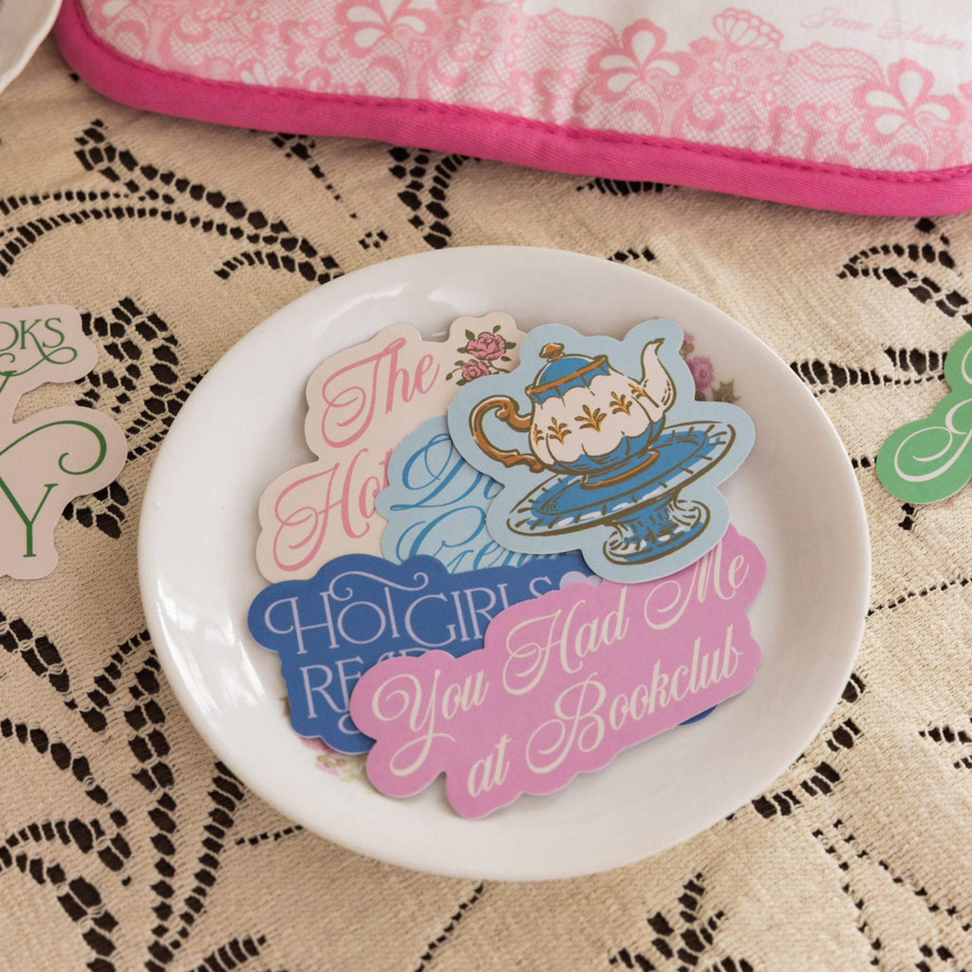 Decorative plate with colorful text and graphics on a lace tablecloth