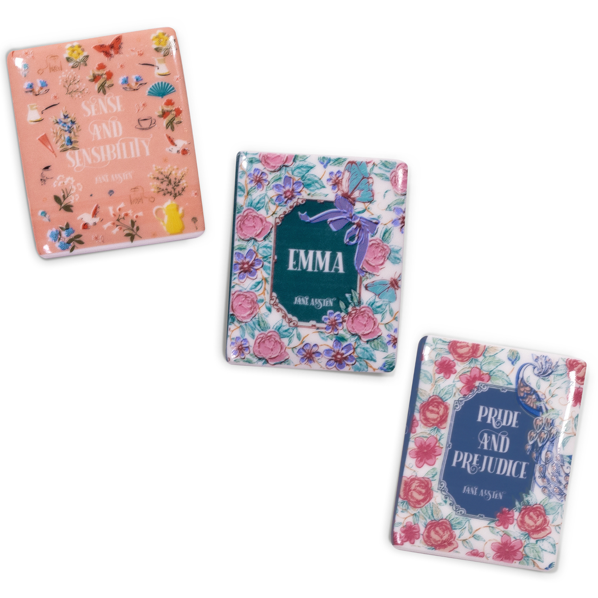 scattered Three book-themed magnets with floral designs and book titles on a white background
