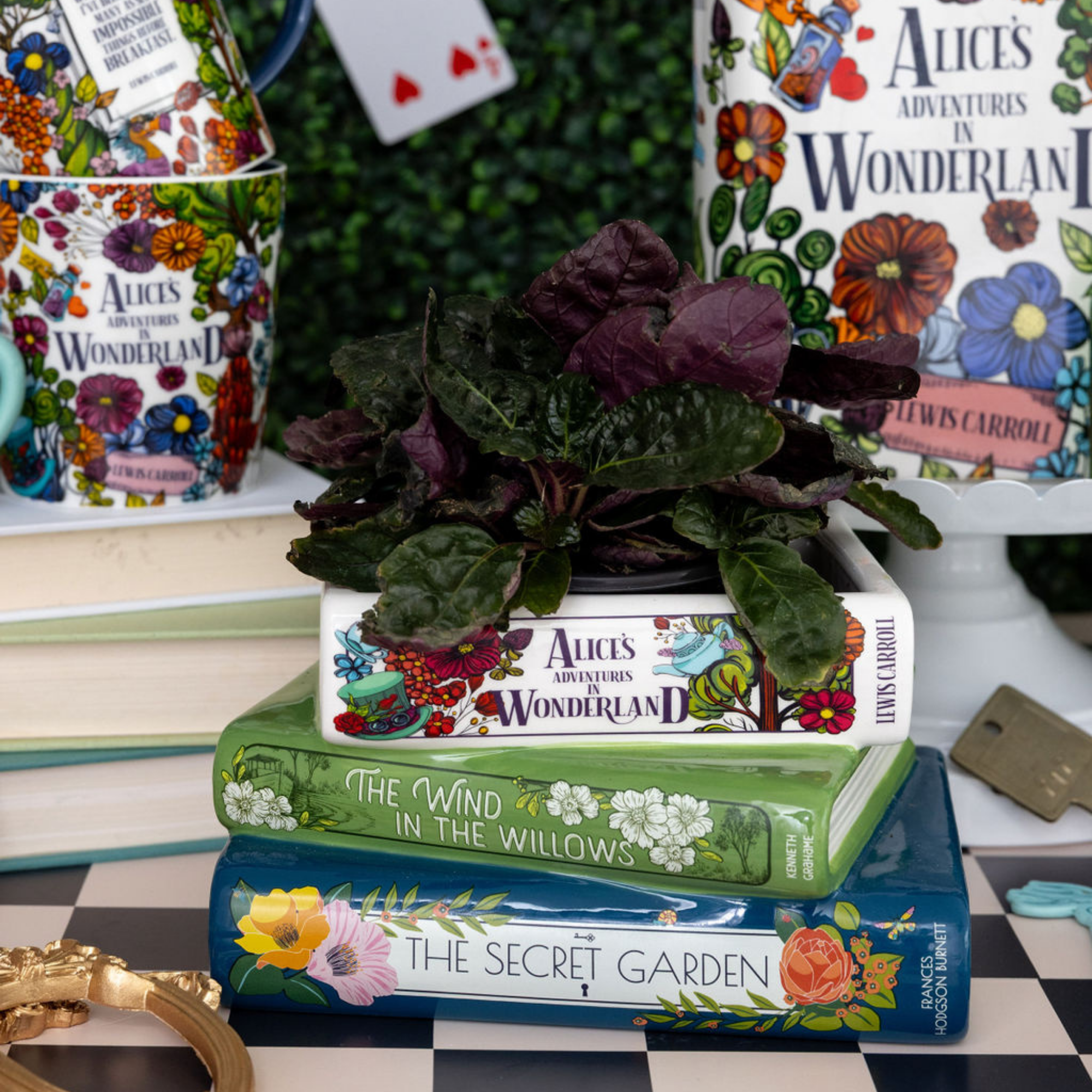 Stack of books with decorative covers featuring illustrations, including 'Alice's Adventures in Wonderland' and 'The Secret Garden'.