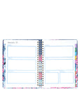 Open planner with colorful floral design on a white background