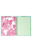 Open planner with pink and white patterned cover and green and white striped interior on a white background