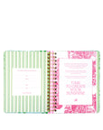 Open planner with green and pink decorative pages on a white background