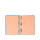 Open spiral-bound planner with peach interior pages on a white background