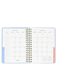 Open planner with monthly calendar layout on a white background