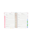 Two open pages of a planner with goal tracking sections on a white background
