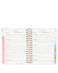 Two open pages of a planner with goal tracking sections on a white background
