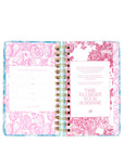 Open planner with floral design on cover and interior pages.