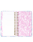 Notebook with pink seashell pattern on a white background