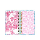 Open planner with pink floral and shell patterns on a white background