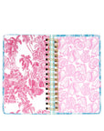 Open planner with pink floral and shell patterns on a white background