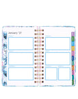 Planner with monthly layout and colorful tabs on a white background
