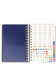 Spiral-bound planner with a blue cover and colorful stickers on a white background