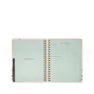 Open planner with a mint green cover and white pages on a white background