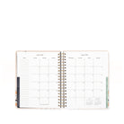 Open planner showing a monthly calendar layout on white background