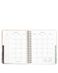 Open planner showing a monthly calendar layout on white background
