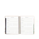 Open planner showing weekly and monthly schedule layout on a white background
