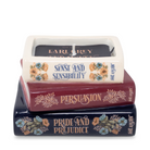 Stack of books with candles labeled 'Pride and Prejudice', 'Persuasion', and 'Sense and Sensibility' on a white background.