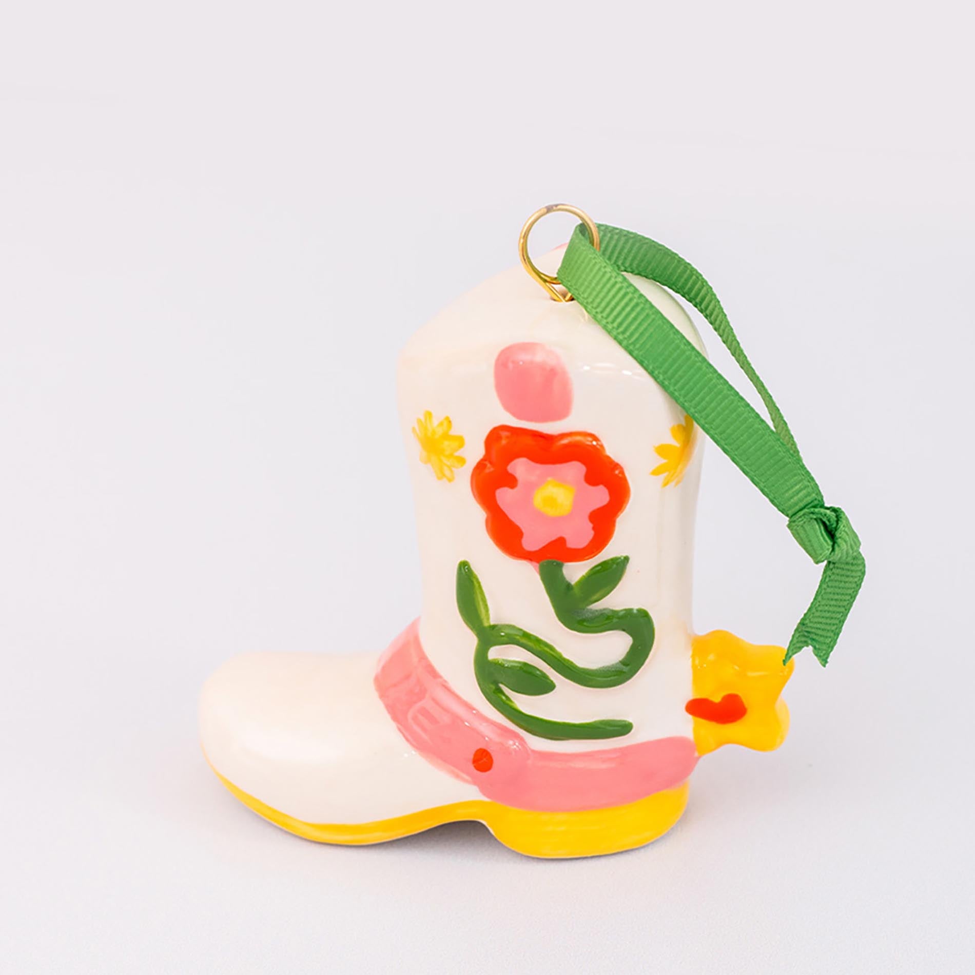 Decorative boot with floral design and green strap on a white background