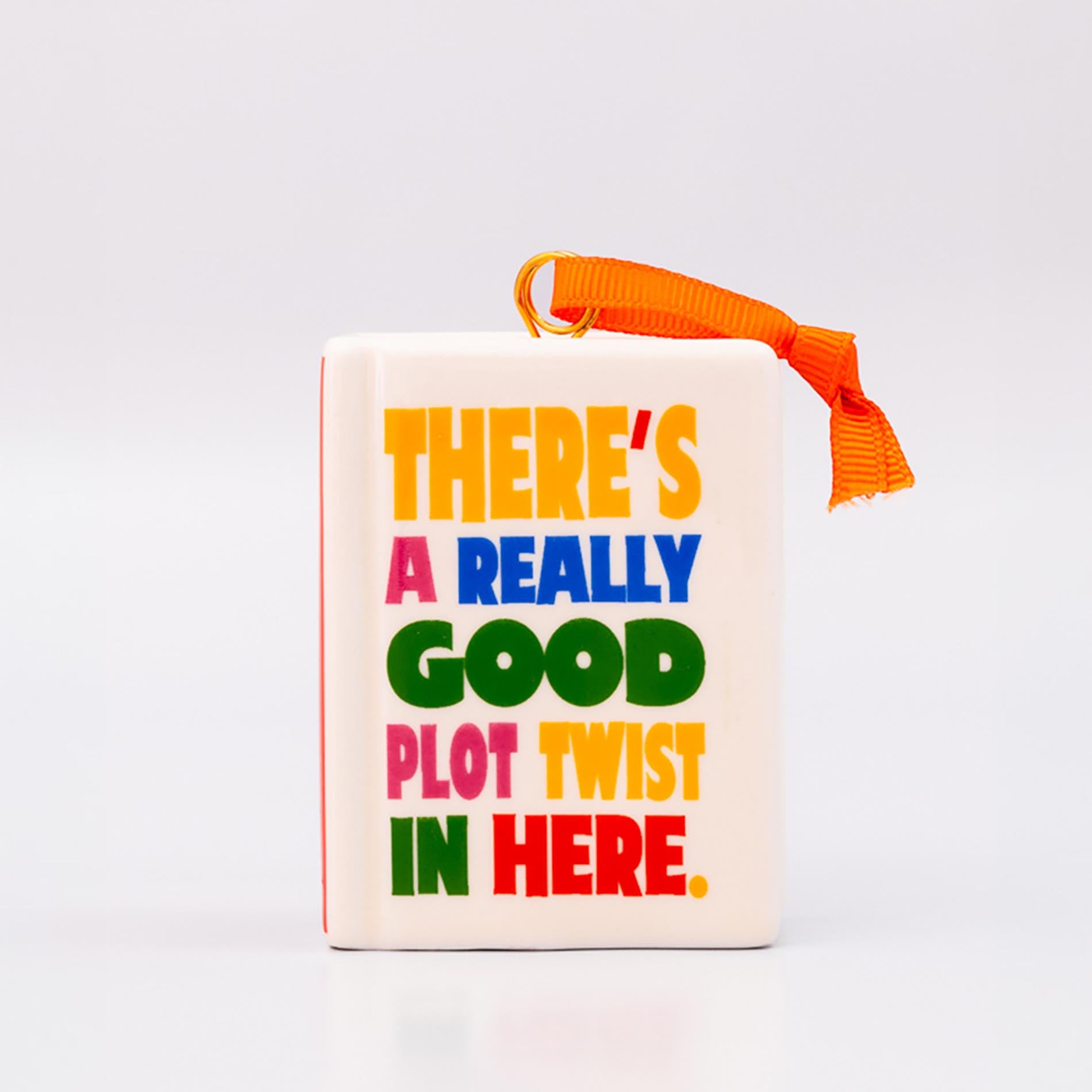Ornament with 'THERE'S A REALLY GOOD PLOT TWIST IN HERE' and an orange hanger on a white background