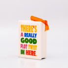 Sideview of ornament with 'THERE'S A REALLY GOOD PLOT TWIST IN HERE' and an orange hanger on a white background