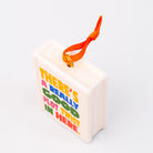 Top view of ornament with 'THERE'S A REALLY GOOD PLOT TWIST IN HERE' and an orange hanger on a white background