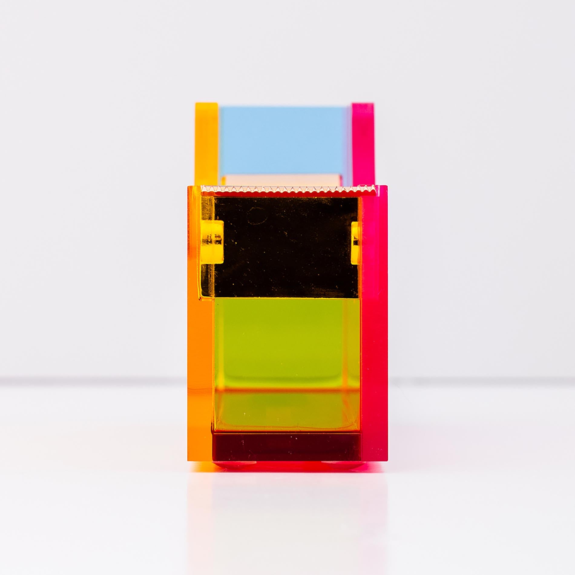 Colorful tape dispenser with a reflective surface on a white background