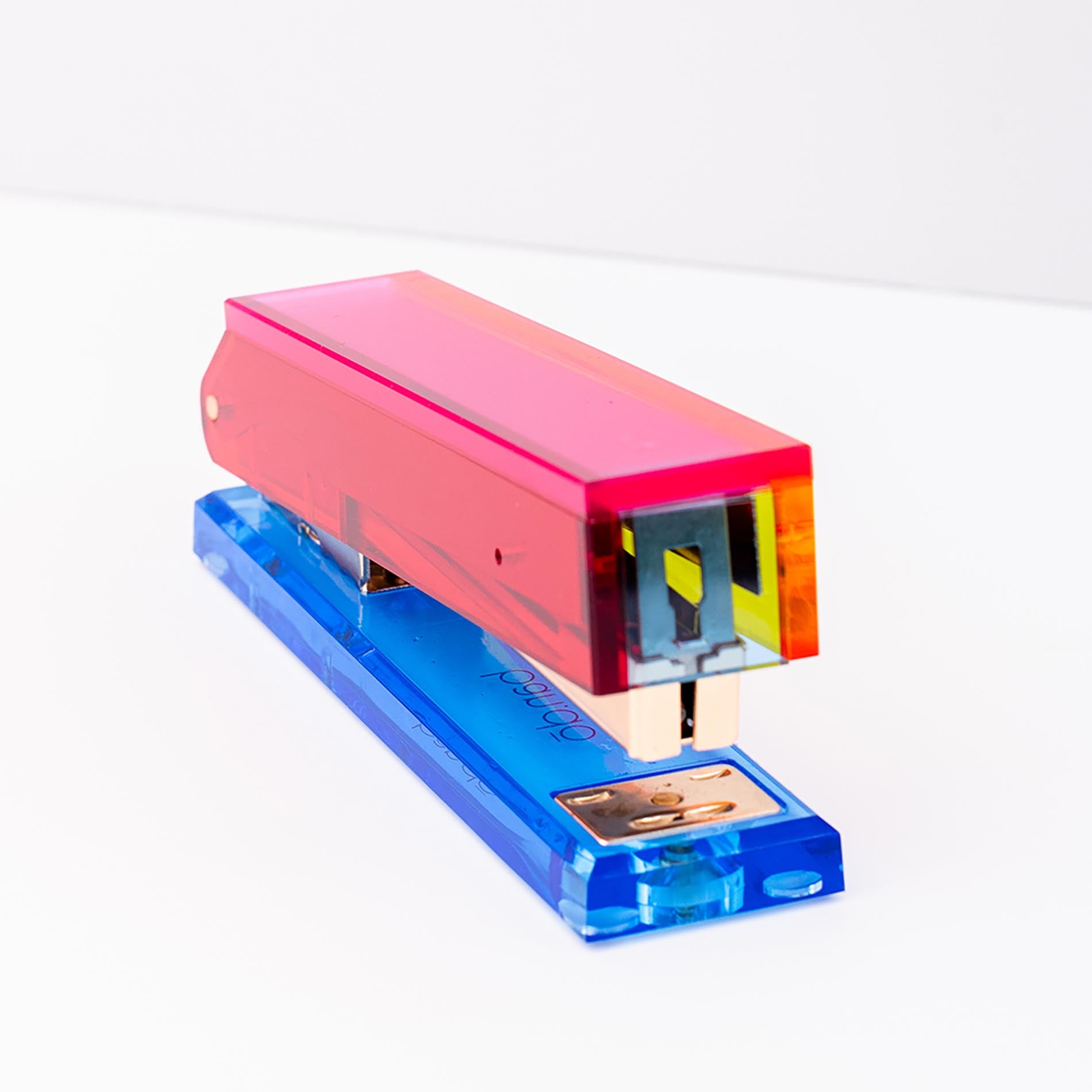 Colorful stapler with pink top and blue base on a white background