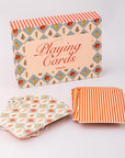 Playing card set with floral and striped design on a light gray background