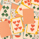 Playing cards with red and green suits on a beige background