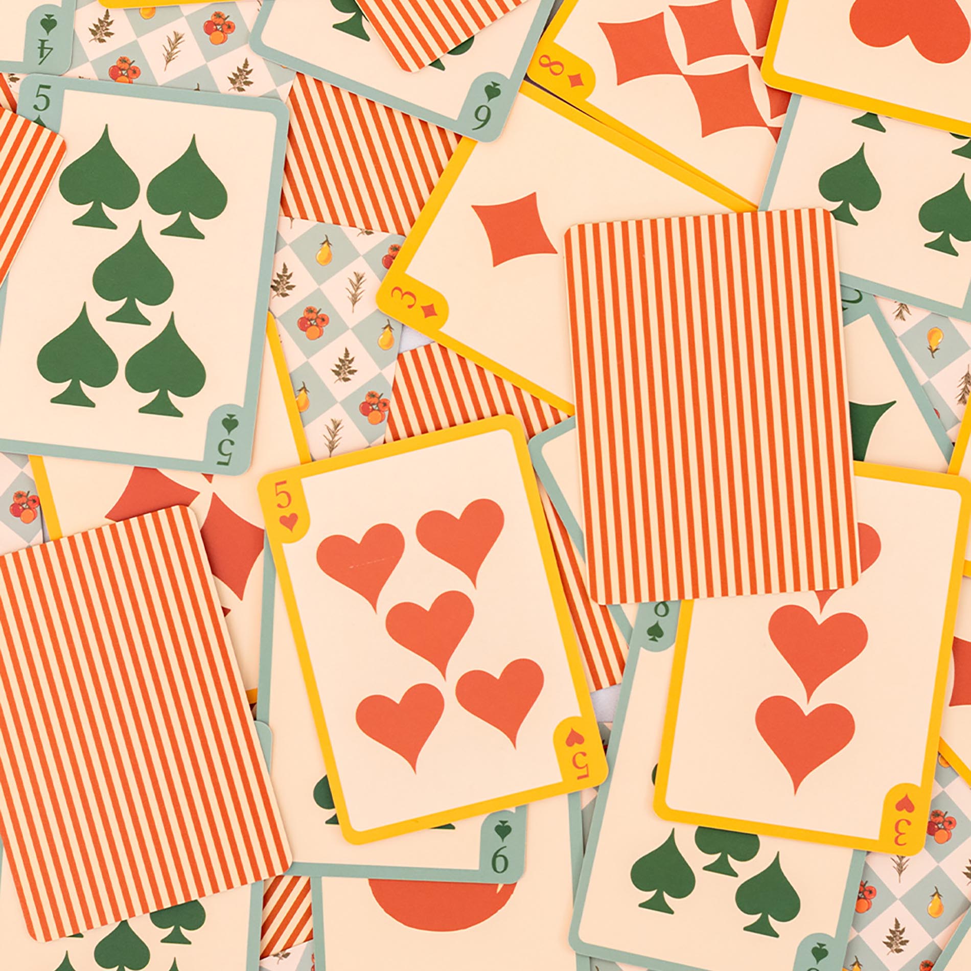 Playing cards with red and green suits on a beige background