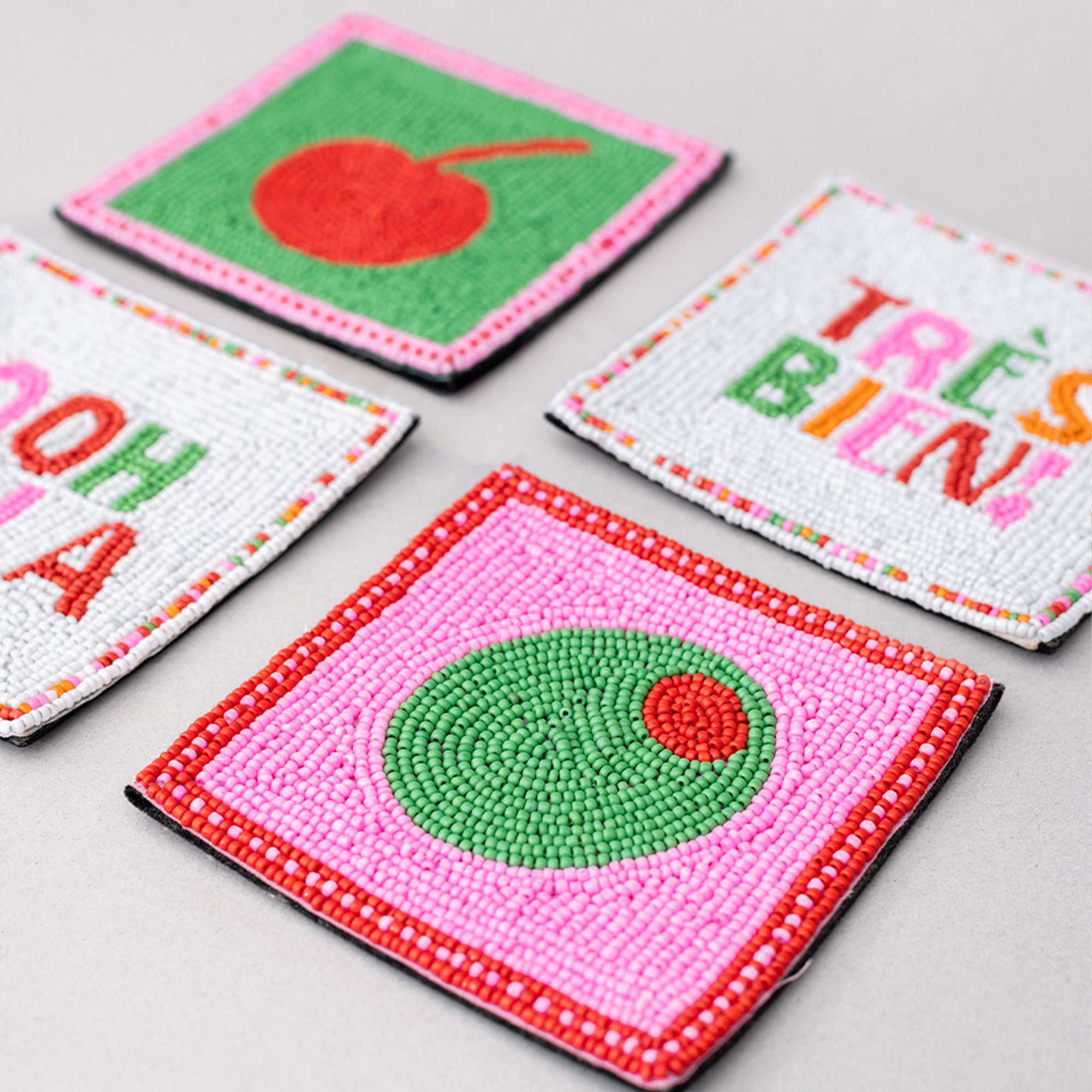 Colorful embroidered coasters with various designs on a light gray surface