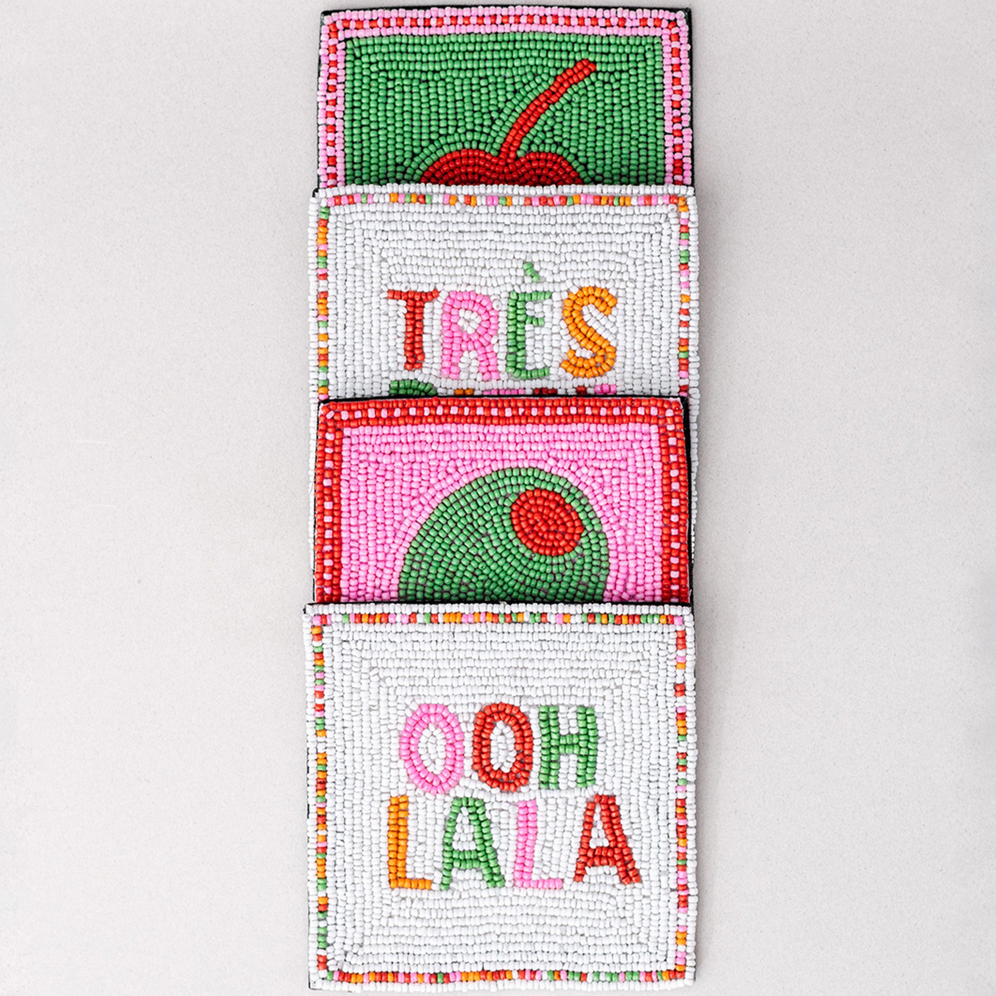 Colorful beaded pocket with 'Trés' and 'Ooh La La' text on a light gray background