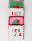 Colorful beaded pocket with 'Trés' and 'Ooh La La' text on a light gray background