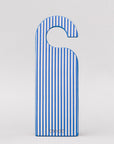 Blue and white striped door hanger on a light gray background